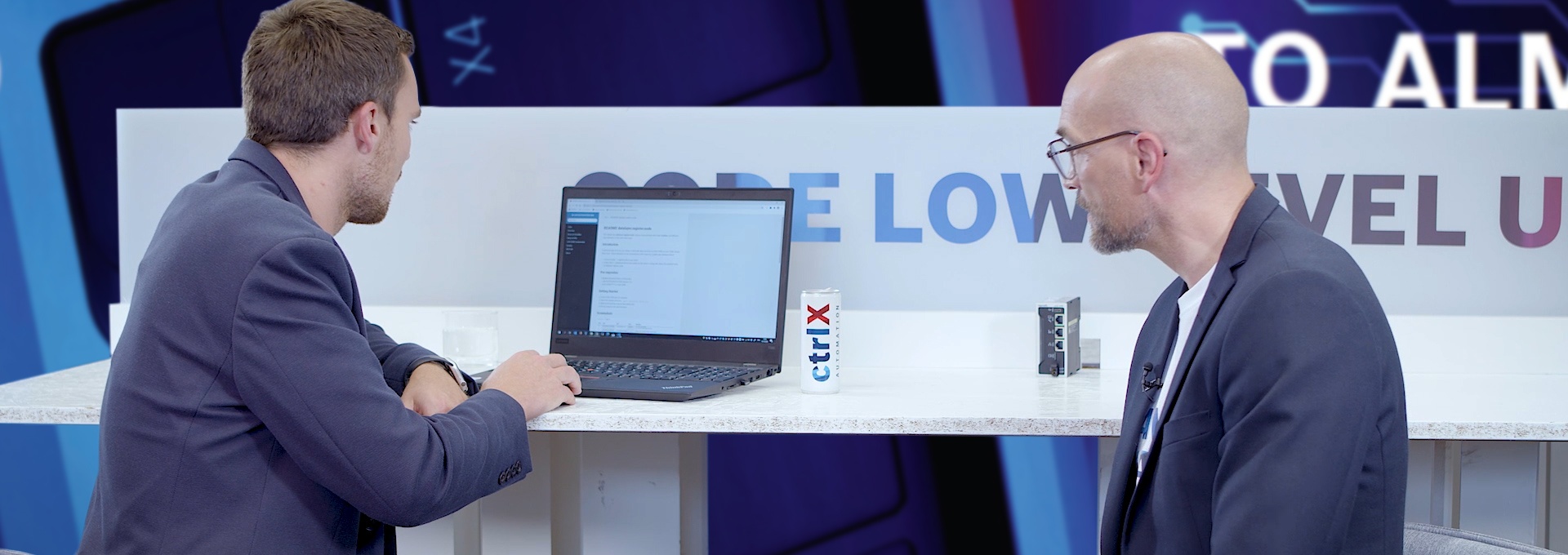 Gastgeber Christian Zentraf und sein Gast Johannes Albrecht sitzen an einem Tisch und sprechen über das Software Development Kit (SDK), zur App-Entwicklung für die Automatisierungslösung ctrlX AUTOMATION