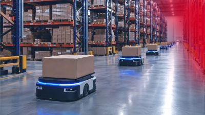 An AGV loaded with packages is driving through a warehouse.