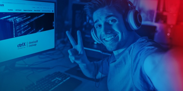 Person mit Headset sitzt am PC und macht ein Victory-Zeichen in die Kamera. Auf dem Monitor ist die ctrlX AUTOMATION Microsite zu sehen.